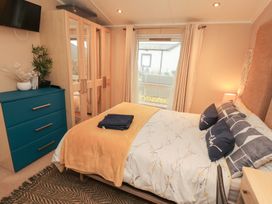 A bedroom with a bed and a dresser at Rosie's Zen Den High Hesket near Armathwaite