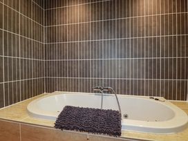 A bathtub with a rug in a bathroom at Sea View in St Austell