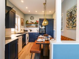 A kitchen with cabinets, a table, and appliances at The Old Post Office in Weymouth