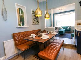 A dining room with a table and benches at The Old Post Office in Weymouth