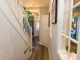 A hallway with a staircase and door at The Old Post Office in Weymouth