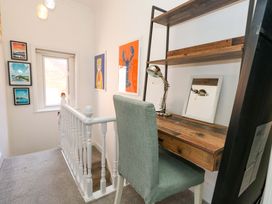 A hallway with a desk and art on the walls at The Old Post Office in Weymouth
