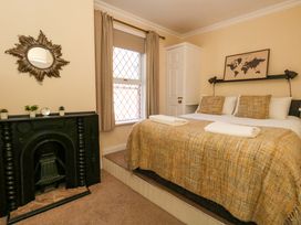 A bedroom with a bed and mirror at The Old Post Office Weymouth