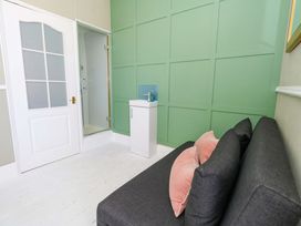 A bathroom with a shower, sink, and sofa at The Old Post Office in Weymouth