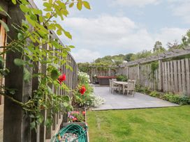 A garden with a patio and furniture at Gloccamaura in Bovey Tracey