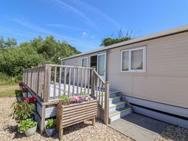 A mobile home with a deck and steps at The Hideaway in Portesham