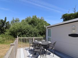 An outdoor deck with a table and chairs at The Hideaway in Portesham