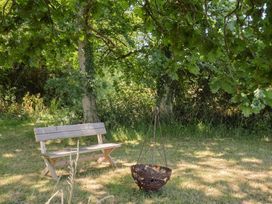 A garden with a bench and a fire pit at The Hideaway in Portesham