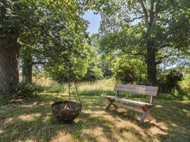 A garden with a bench and a fire pit at The Hideaway in Portesham