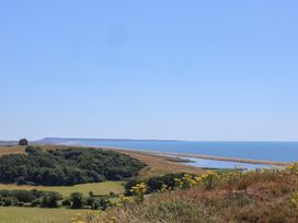 A coastal view with hills and a beach at The Hideaway Portesham