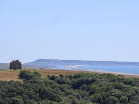 A distant view of a building near a beach and ocean at The Hideaway in Portesham