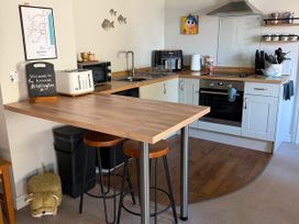 A kitchen with a counter and stools at The Annexe Bridlington