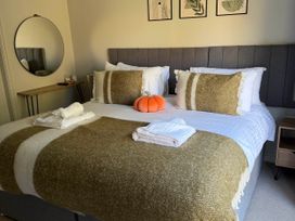 A bedroom with a bed, pillows, towels, and a mirror at The Annexe in Bridlington