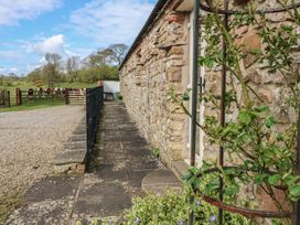 A pathway beside a stone wall at Rainbow Cottage in Kirkby Stephen