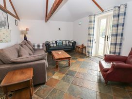 A living room with furniture and a door at Rainbow Cottage in Kirkby Stephen