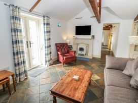 A living room with a sofa and armchair at Rainbow Cottage in Kirkby Stephen