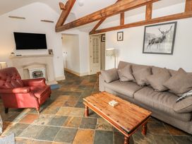 A living room with a television and fireplace at Rainbow Cottage in Kirkby Stephen