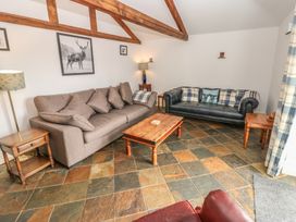 A living room with sofas and a table at Rainbow Cottage in Kirkby Stephen