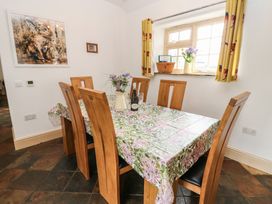 A dining room with a table set for dinner at Rainbow Cottage in Kirkby Stephen