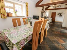 A kitchen with a dining table and chairs at Rainbow Cottage in Kirkby Stephen
