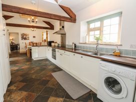 A kitchen with a washing machine and sink at Rainbow Cottage in Kirkby Stephen