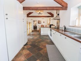 A kitchen with cabinets and appliances at Rainbow Cottage in Kirkby Stephen