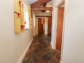 A hallway with a staircase and window at Rainbow Cottage in Kirkby Stephen