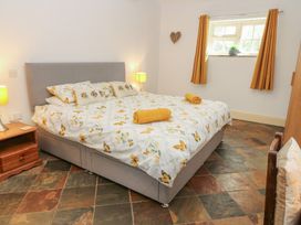 A bedroom with a bed and a bedside table at Rainbow Cottage in Kirkby Stephen