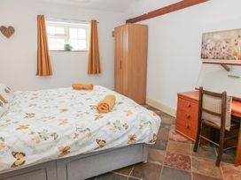 A bedroom with a bed and desk at Rainbow Cottage in Kirkby Stephen