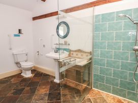 A bathroom with a sink, toilet and shower at Rainbow Cottage in Kirkby Stephen