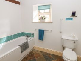 A bathroom with a bath tub and toilet at Rainbow Cottage in Kirkby Stephen