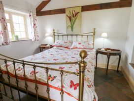 A bedroom with a bed and nightstands at Rainbow Cottage Kirkby Stephen