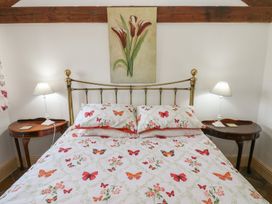 A bedroom with a bed and lamps at Rainbow Cottage in Kirkby Stephen