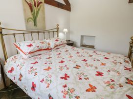 A bedroom with a bed and lamp at Rainbow Cottage in Kirkby Stephen