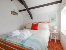 A bedroom with a bed and towels at Ivy Cottage in Trenale near Tintagel