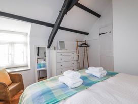 A bedroom with towels on the bed at Ivy Cottage in Trenale near Tintagel