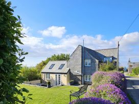 A house with a garden and bench at Ivy Cottage in Trenale near Tintagel