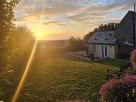 A sunset over a garden with a house at Ivy Cottage, Trenale near Tintagel