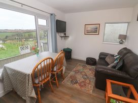 A living room with a table and chairs at Sandyfeet near Roskear Croft Camborne