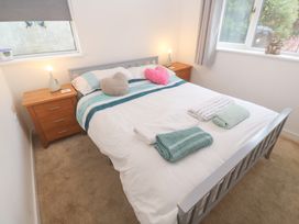A bedroom with a bed and nightstands at Sandyfeet Roskear Croft near Camborne