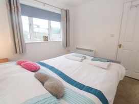 A bedroom with a double bed and window at Sandyfeet in Roskear Croft near Camborne