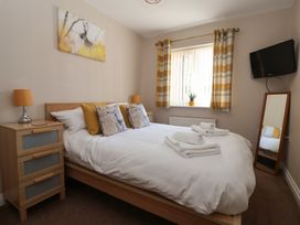 A bedroom with a bed, television, and window at Church View in Withernwick near Aldbrough