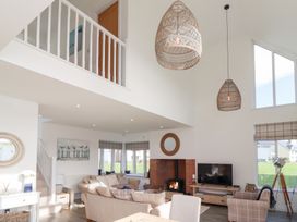 A living room with a sofa, fireplace, and television at The Beach House (Beadnell)