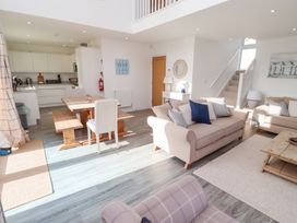 A living room with a dining table and kitchen at The Beach House in Beadnell