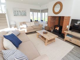 A living room with a sofa, coffee table, and fireplace at The Beach House (Beadnell)