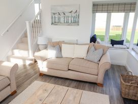 A living room with a sofa and cushions at The Beach House in Beadnell
