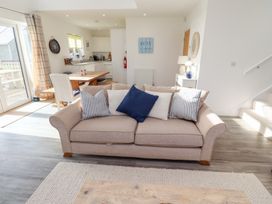 A living room with a sofa and dining table at The Beach House in Beadnell