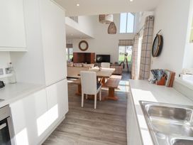 A kitchen with a dining table and sofa at The Beach House in Beadnell