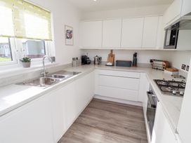 A kitchen with a sink, stove, and cabinets at The Beach House (Beadnell) Beadnell