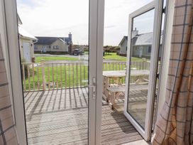 A view from inside through an open door onto a deck at The Beach House in Beadnell